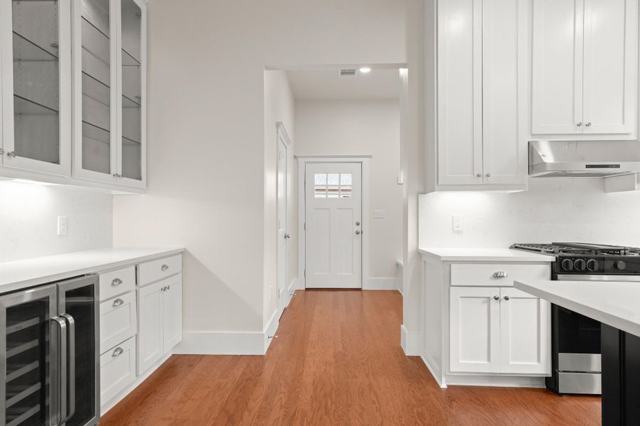 A well-appointed kitchen features rich wood flooring, gleaming white cabinetry, and stainless steel appliances. A well-appointed kitchen features rich wood flooring, gleaming white cabinetry, and stainless steel appliances.