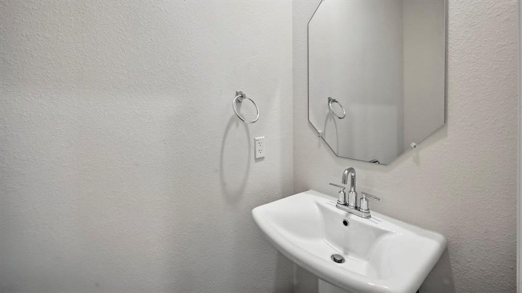 Bathroom with a sink and a textured wall