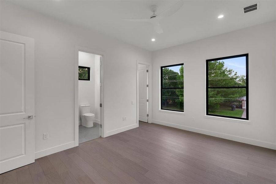 Unfurnished bedroom featuring ensuite bath, ceiling fan, and light hardwood / wood-style flooring