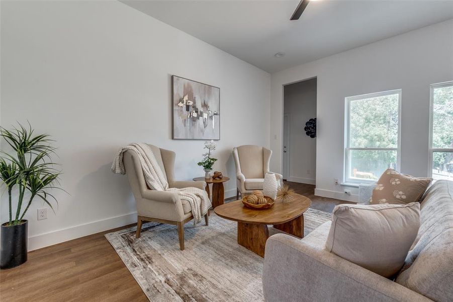 Living area with a healthy amount of sunlight and hardwood / wood-style flooring