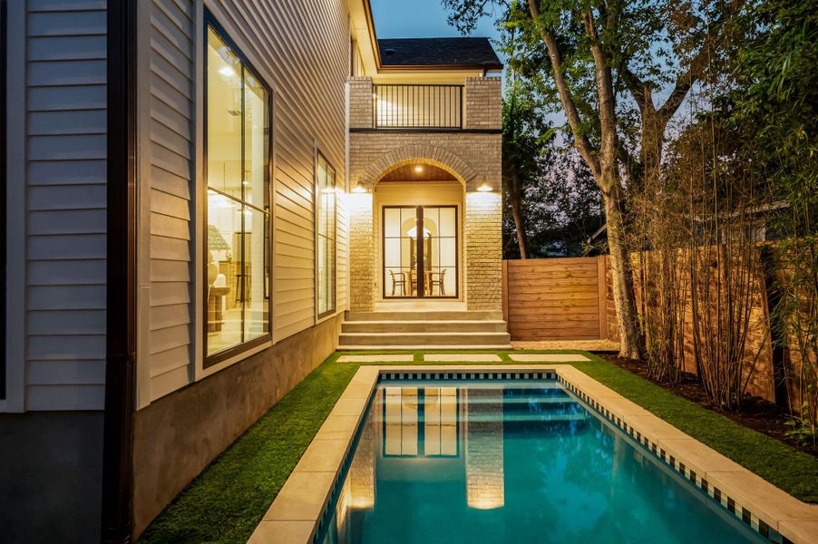 Reflecting modern elegance, a pristine backyard pool awaits, surrounded by manicured turf and a privacy fence.