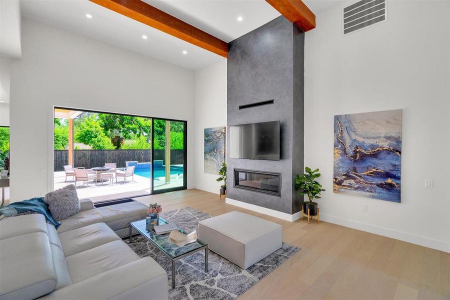 Living room featuring wood finished floors, a fireplace, and recessed lighting