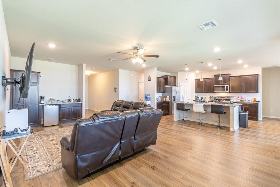 An open concept living space seamlessly blends a modern kitchen with rich cabinetry and an inviting breakfast bar.