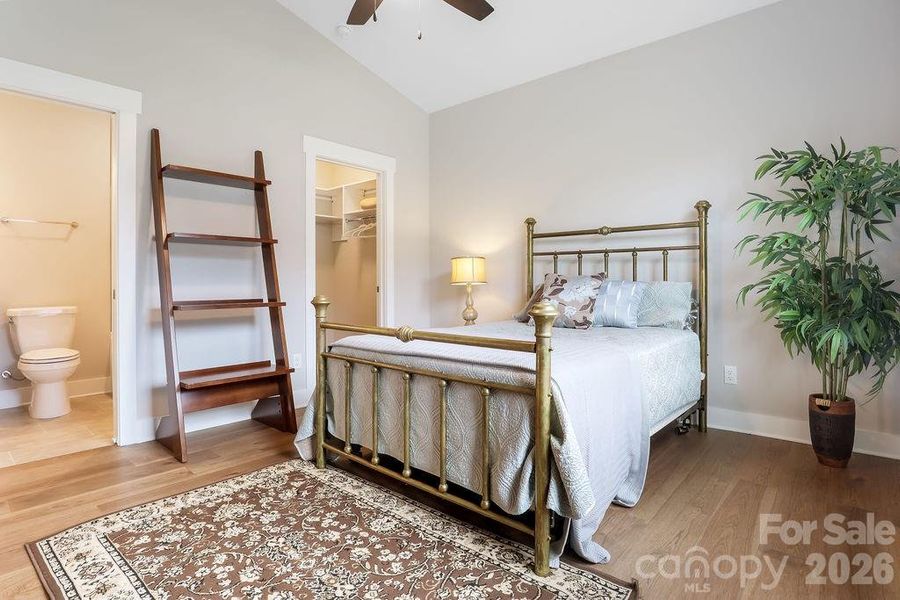 Secondary, main level bedroom has walk-in closet and ensuite bathroom, vaulted ceiling with ceiling fan.