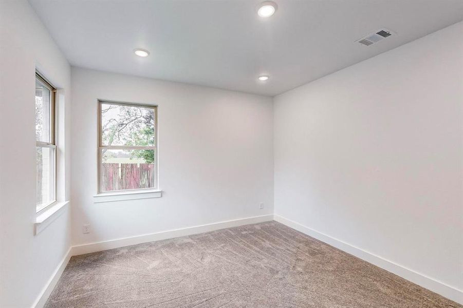 Empty room featuring a healthy amount of sunlight and carpet flooring