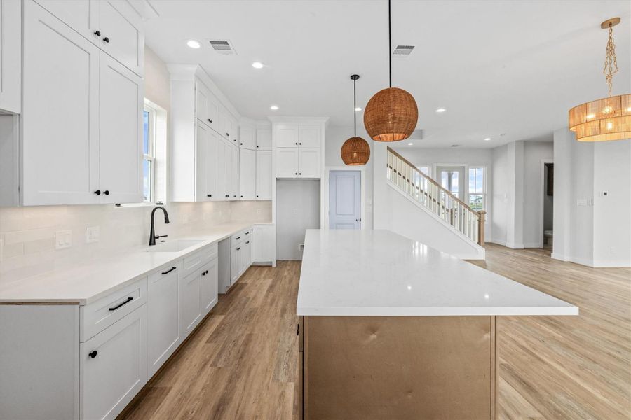 Experience the elegance of this spacious kitchen, featuring a large island with seamless views of the dining and living areas.