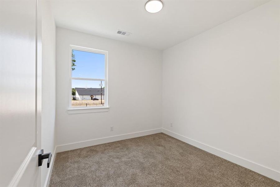 Carpeted spare room with baseboards