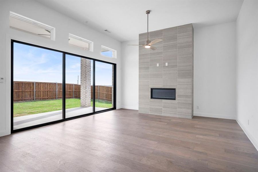 Unfurnished living room featuring ceiling fan, hardwood / wood-style flooring, and plenty of natural light