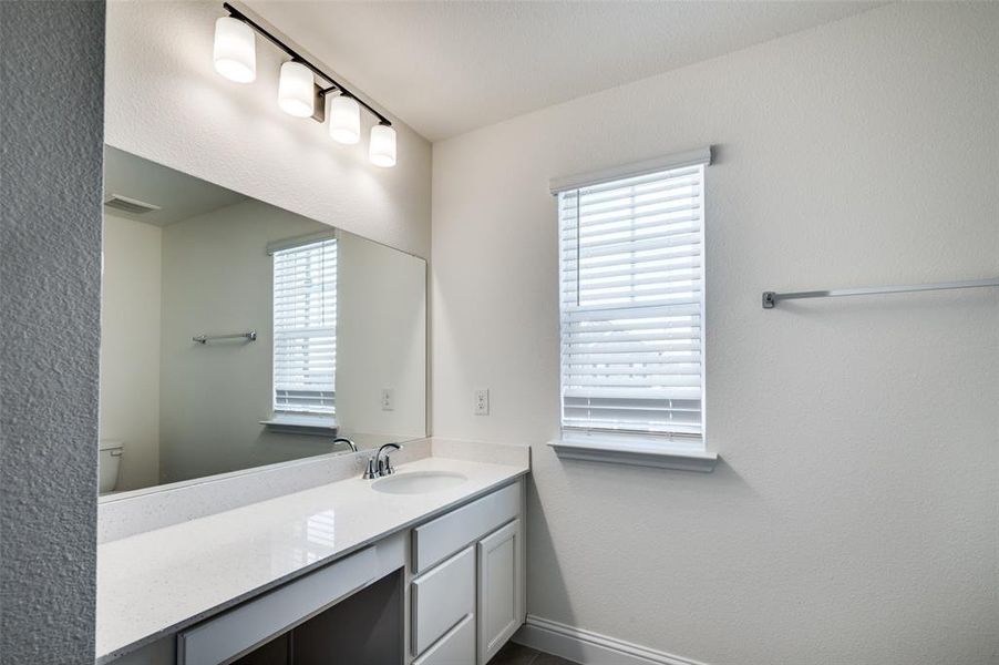 Bathroom with a textured wall and vanity Bathroom with a textured wall and vanity