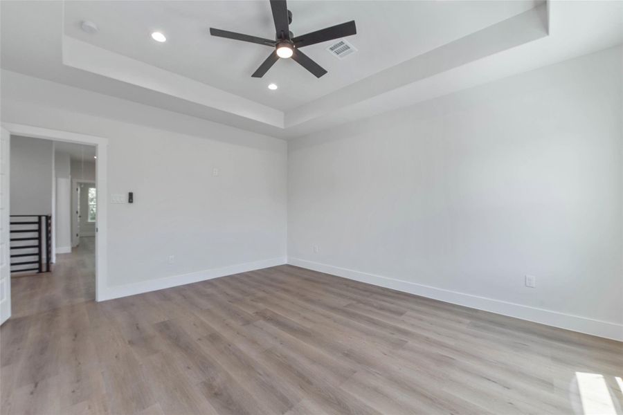 The primary bedroom features a beautifully recessed ceiling, adding depth and architectural interest to the space. The primary bedroom features a beautifully recessed ceiling, adding depth and architectural interest to the space.