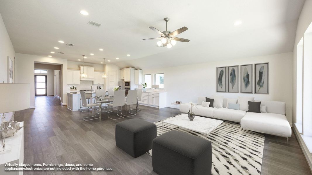 Living area with plenty of natural light, recessed lighting, dark wood-type flooring, vaulted ceiling, and a ceiling fan Living area with plenty of natural light, recessed lighting, dark wood-type flooring, vaulted ceiling, and a ceiling fan