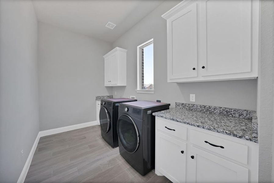 Laundry room with cabinet space, washing machine and dryer, and baseboards Laundry room with cabinet space, washing machine and dryer, and baseboards