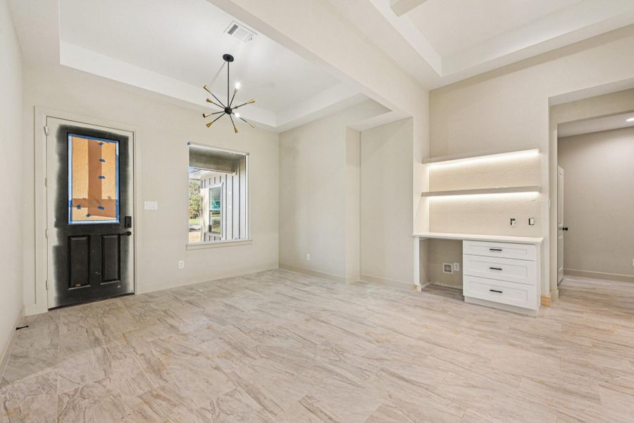 The space features a charming coffee station, a built-in desk with shelves, and a window that brings in beautiful natural light.