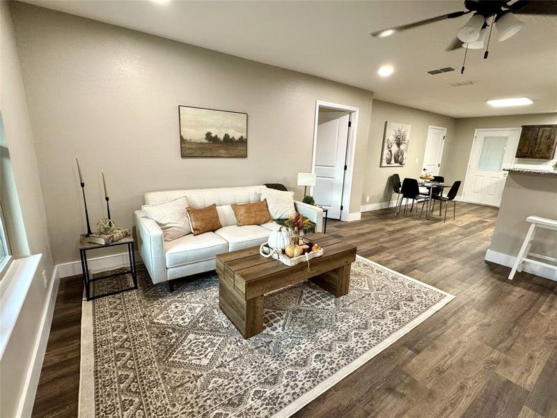 Living room with dark wood-style floors, recessed lighting, and ceiling fan