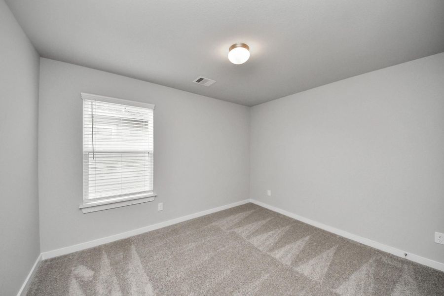 Secondary bedroom features plush carpeting, large windows that let in plenty of natural light, bright paint, and spacious closets.
