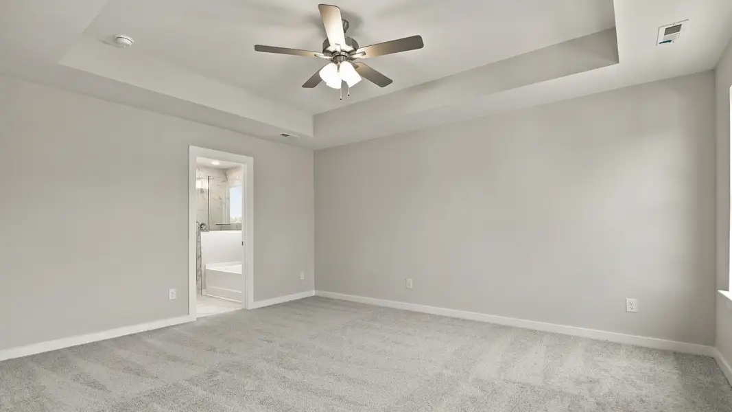 Spacious primary bedroom with tray ceilings for a lavish feeling Spacious primary bedroom with tray ceilings for a lavish feeling
