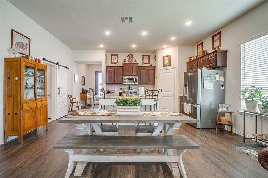 Dining area featuring a barn door, dark wood-type flooring, and recessed lighting Dining area featuring a barn door, dark wood-type flooring, and recessed lighting