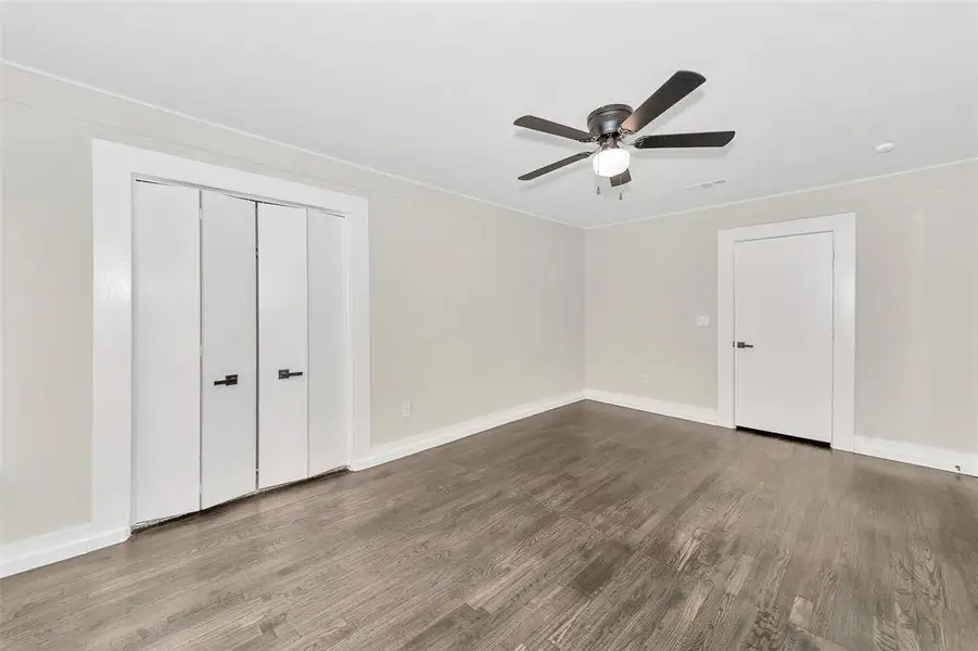 Unfurnished bedroom with visible vents, baseboards, and wood finished floors