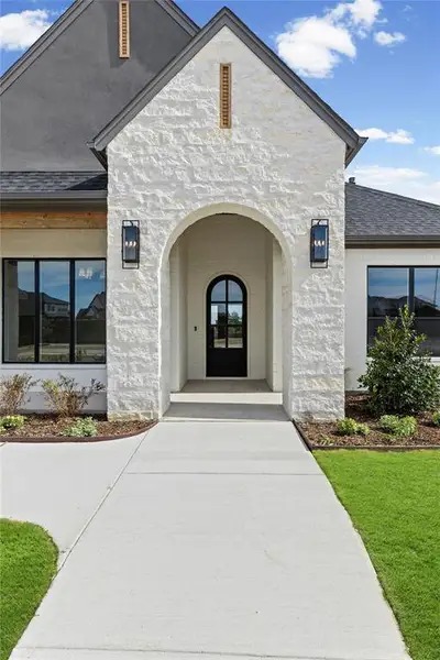 Entrance to property with roof with shingles and brick siding