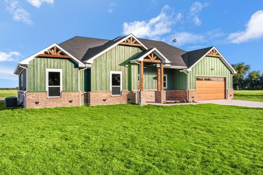 Craftsman-style home featuring board and batten siding, a front yard, a garage, and concrete driveway Craftsman-style home featuring board and batten siding, a front yard, a garage, and concrete driveway
