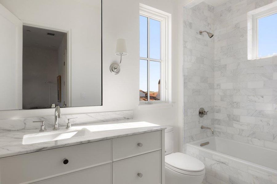 Bathroom with vanity and a combined bath / shower with marble appearance