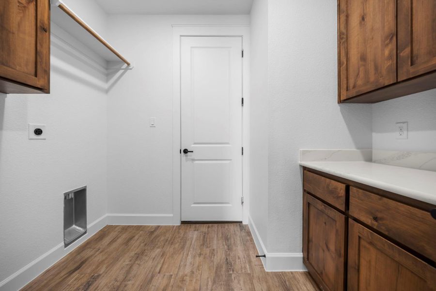 Laundry area featuring cabinet space, light wood-style floors, and electric dryer hookup