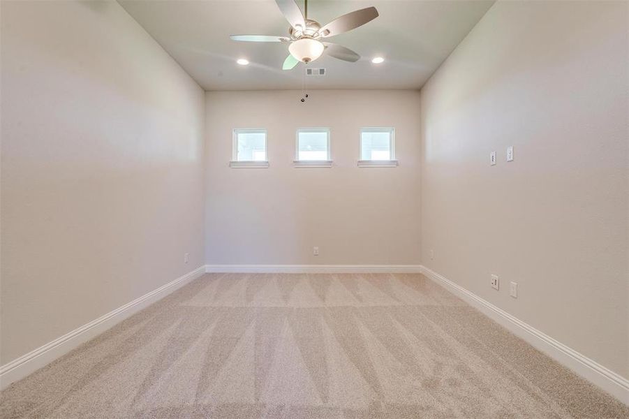 Unfurnished room featuring ceiling fan and light colored carpet