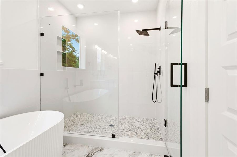 This bathroom features a spacious glass-enclosed shower with a mosaic tile floor, a rain showerhead, and a handheld shower fixture
