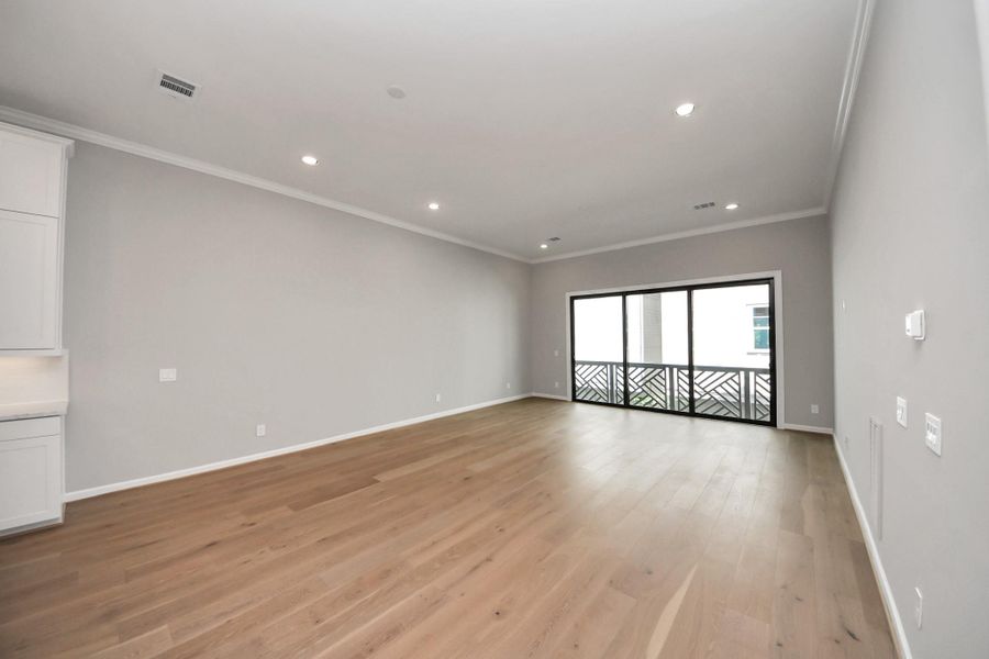 Open-concept living area with engineered wood flooring and abundant natural light. Open-concept living area with engineered wood flooring and abundant natural light.