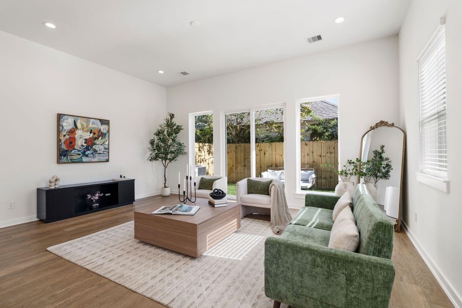 Surrounded by large windows creating a bright and airy atmosphere while offering beautiful views of the backyard.