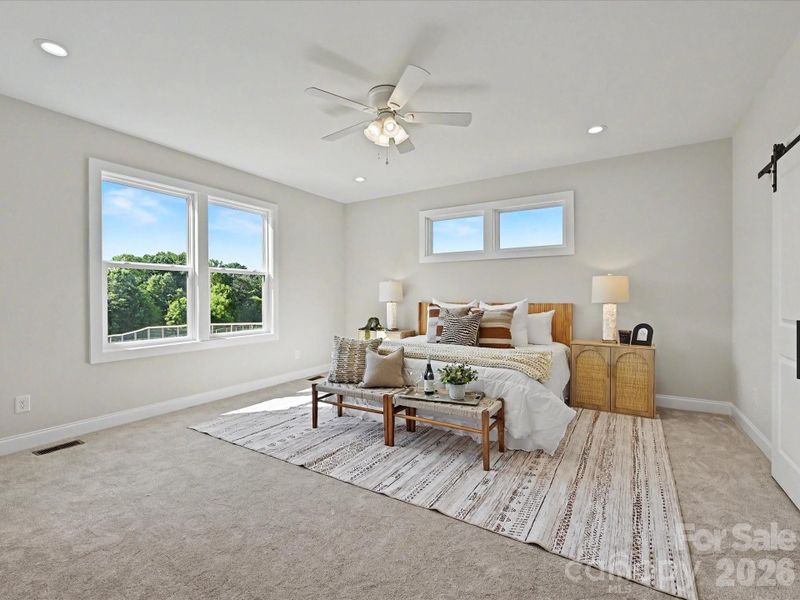 Spacious primary suite offers a peaceful retreat with abundant natural light, plush carpeting, and private access to the spa-inspired en-suite bath.
