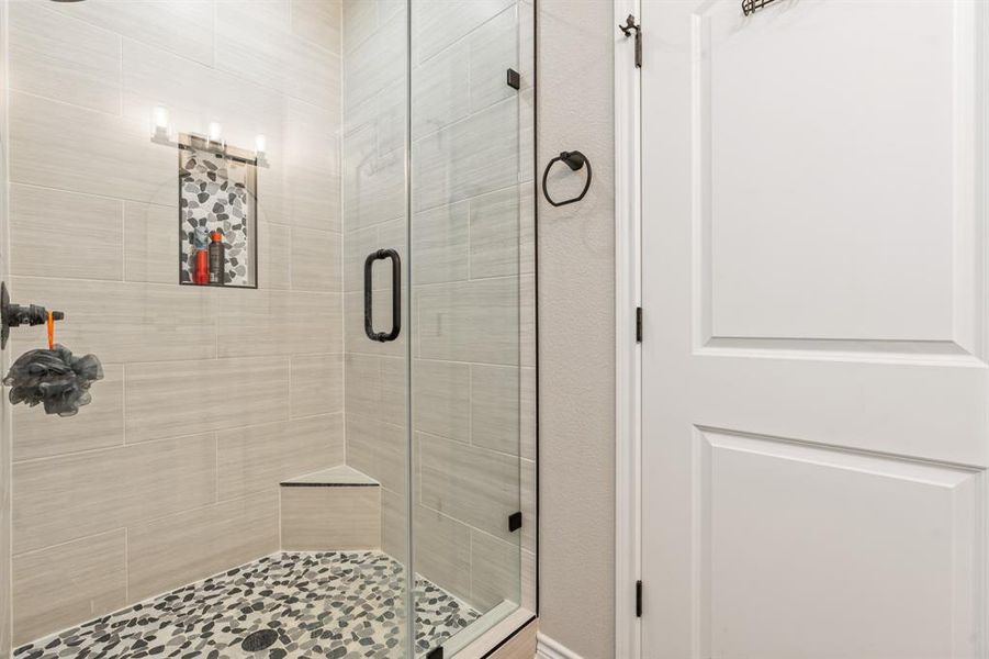 Primary bath featuring a tiled shower Primary bath featuring a tiled shower