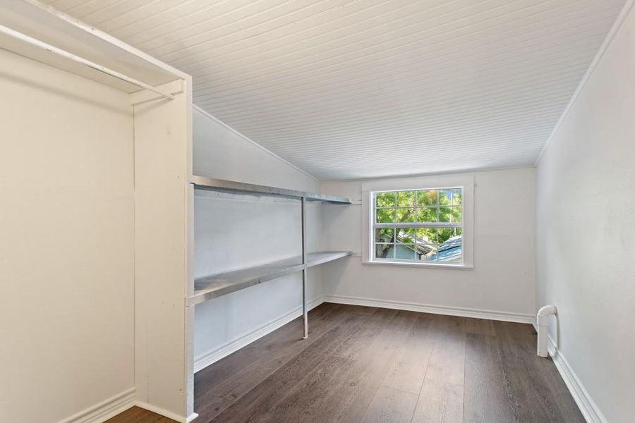 Walk in closet with vaulted ceiling and hardwood / wood-style flooring