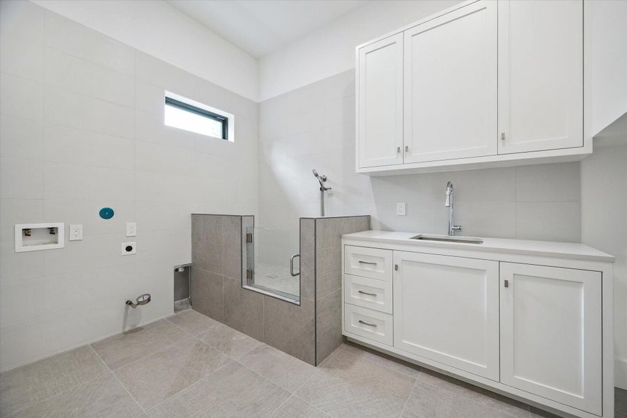 Spacious utility room with dog wash station and built-in cabinetry. Spacious utility room with dog wash station and built-in cabinetry.