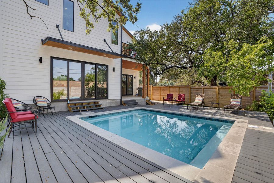 View of pool featuring a patio and a wooden deck