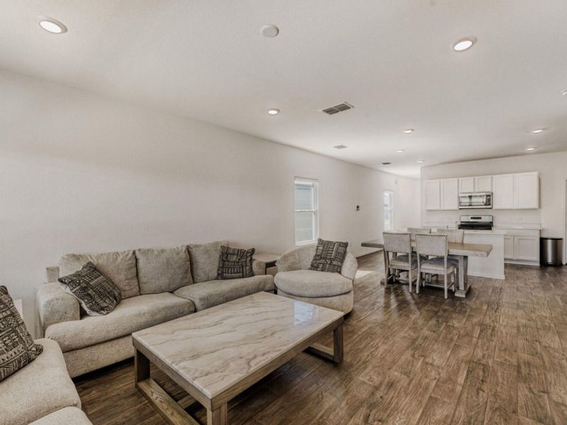 Living area with dark wood finished floors and recessed lighting