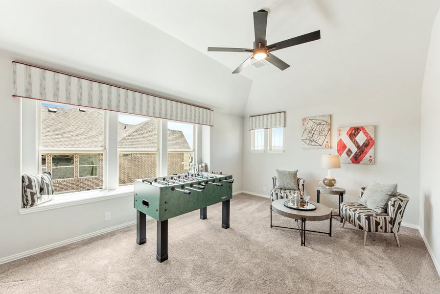 Game room with foosball table, seating area, vaulted ceiling, and ceiling fan on carpet flooring Game room with foosball table, seating area, vaulted ceiling, and ceiling fan on carpet flooring
