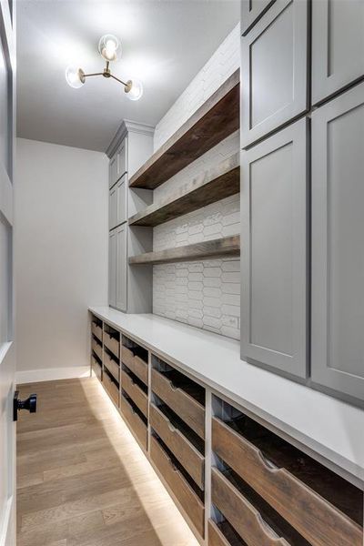 Spacious closet featuring light wood-type flooring Spacious closet featuring light wood-type flooring