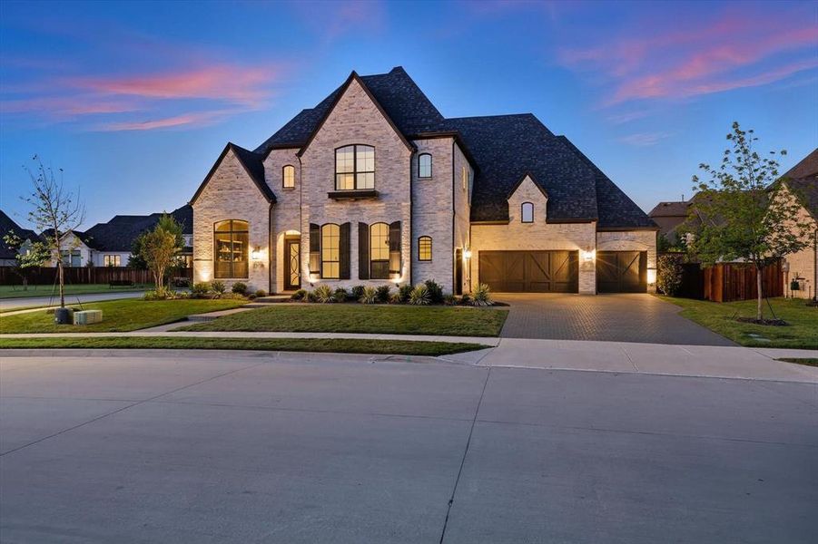 French provincial home with driveway, a 4-car garage, stone siding, and brick siding French provincial home with driveway, a 4-car garage, stone siding, and brick siding