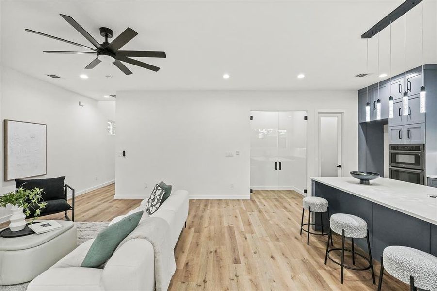 Living room with light hardwood / wood-style floors and ceiling fan