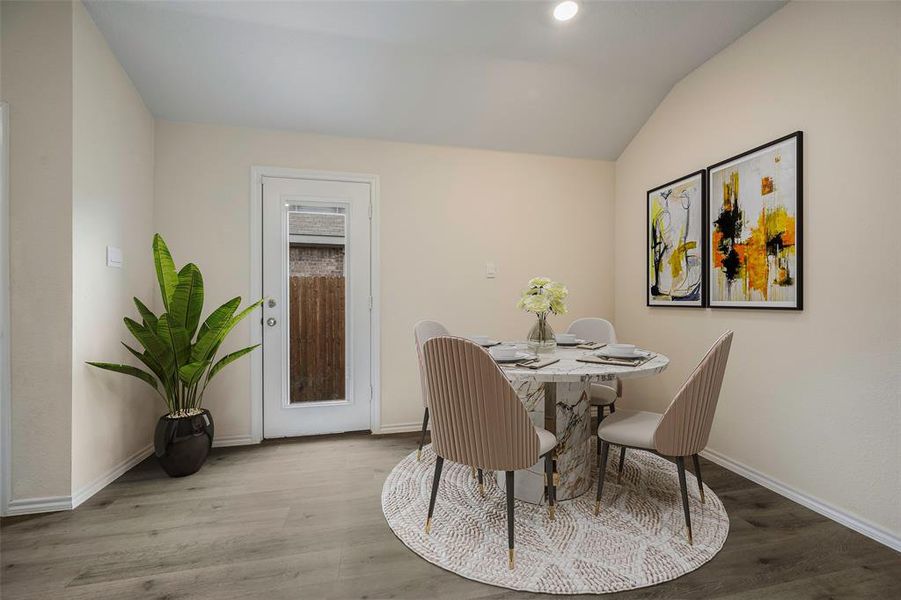 Dining area featuring wood finished floors and vaulted ceiling