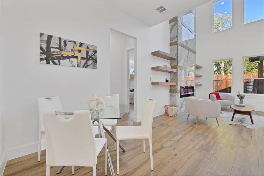 Dining room featuring wood finished floors, baseboards, and a high ceiling