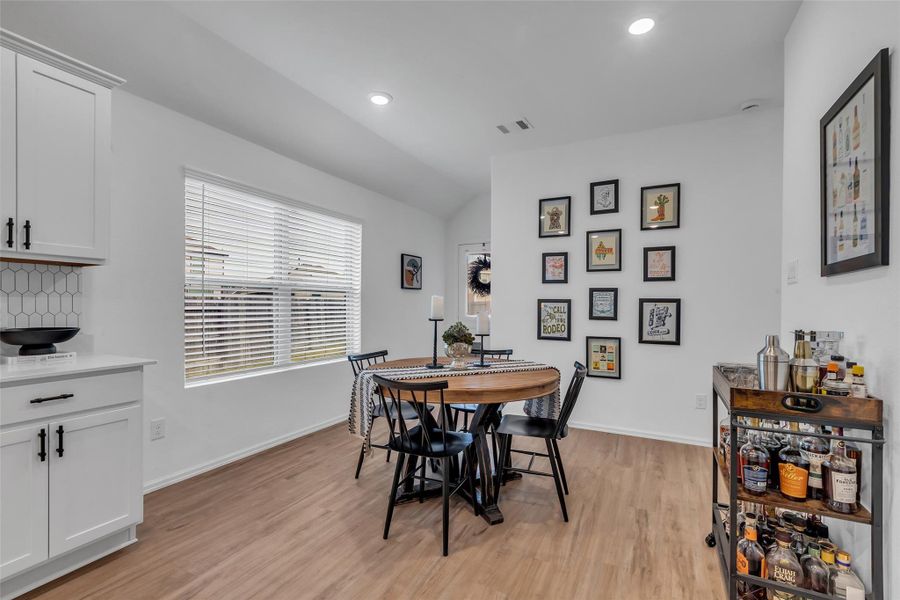 Plenty of seating room in this dining area. To the left of the table is one of the many large windows that make this home so inviting, to the right of the table is the hallway that leads to the laundry room and primary bedroom and bath.