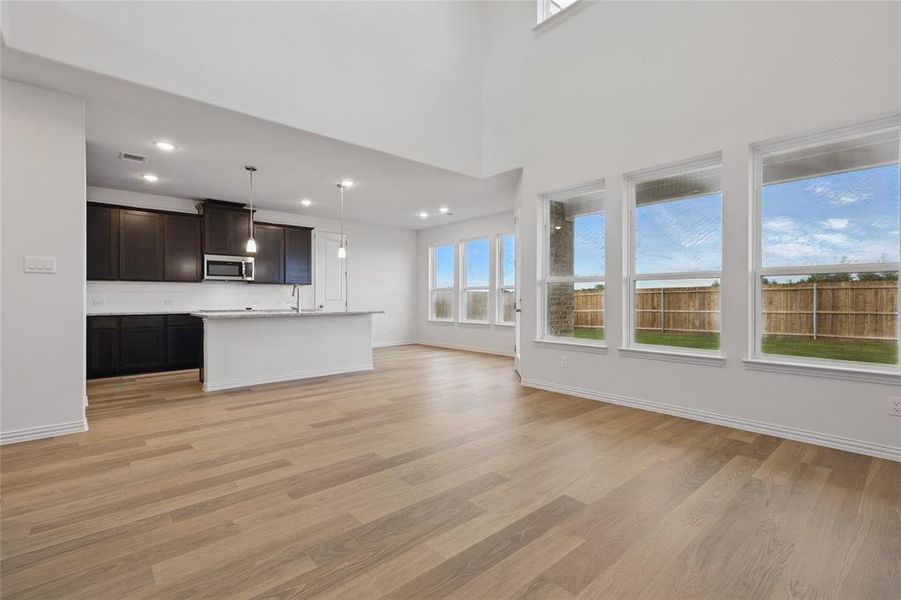 Unfurnished living room with light wood-style floors, a sink, baseboards, and recessed lighting Unfurnished living room with light wood-style floors, a sink, baseboards, and recessed lighting