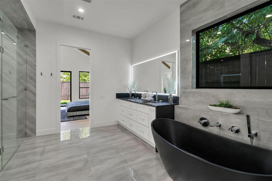 Bathroom with vanity, a soaking tub, an enclosed shower, lofted ceiling, and connected bathroom Bathroom with vanity, a soaking tub, an enclosed shower, lofted ceiling, and connected bathroom