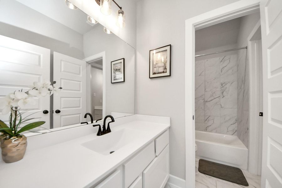 Jack-and-Jill bath with long vanity and separate tub/shower room.