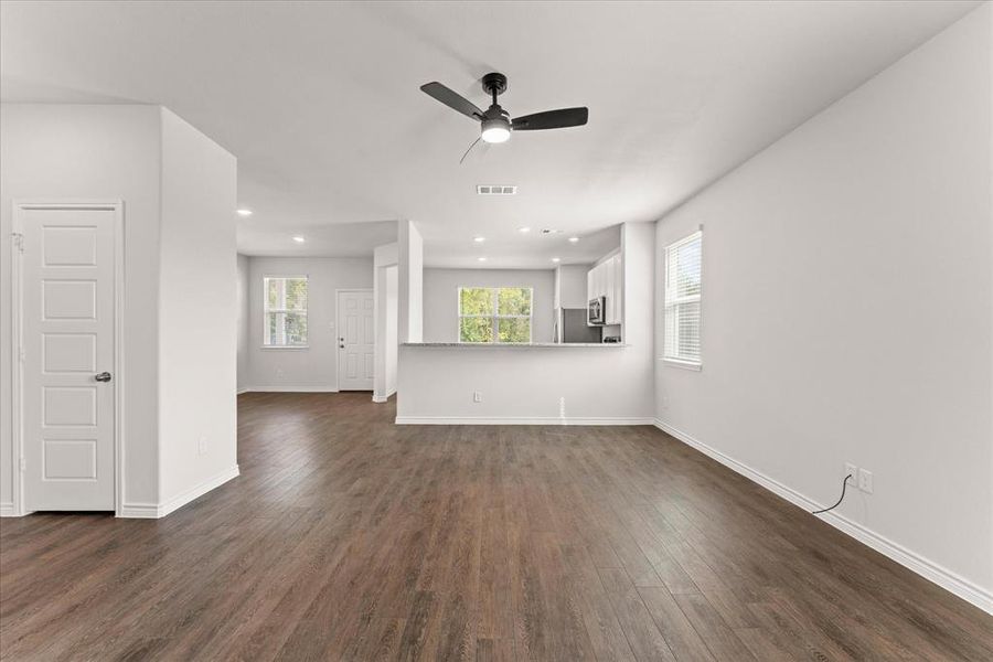 Unfurnished living room featuring dark wood finished floors, ceiling fan, and recessed lighting Unfurnished living room featuring dark wood finished floors, ceiling fan, and recessed lighting