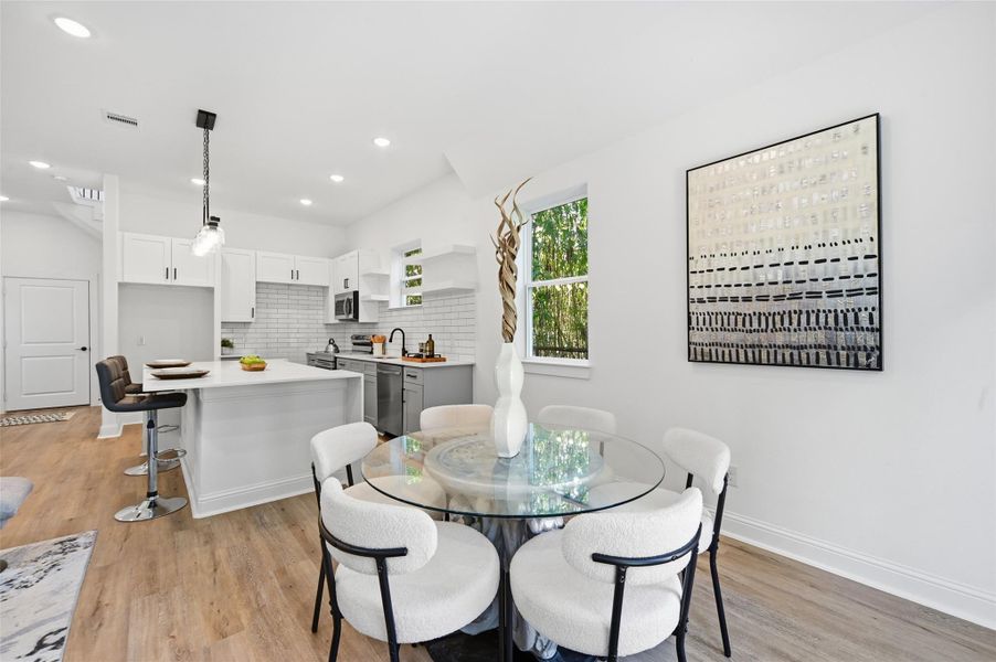 Open concept kitchen, dining and living room, with lots of natural light.