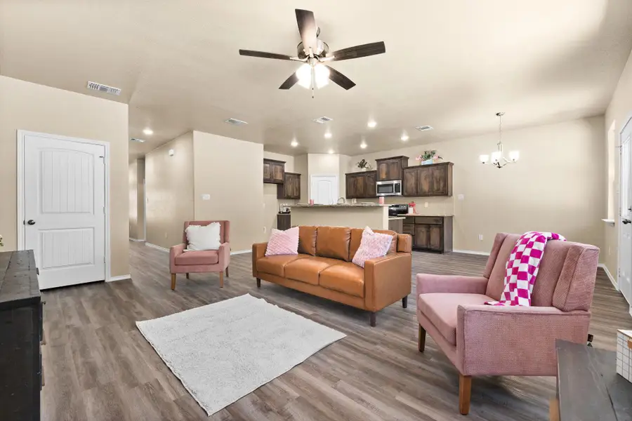 Living room with wood finished floors, a chandelier, ceiling fan, and recessed lighting