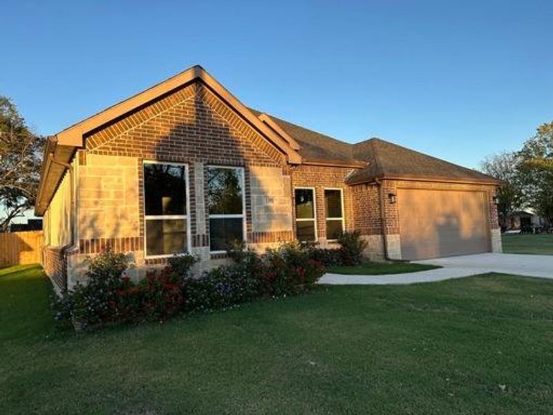 View of front of house with a garage and a front lawn